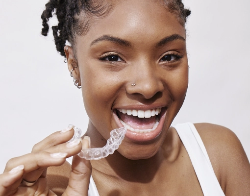 happy woman holding clear aligners